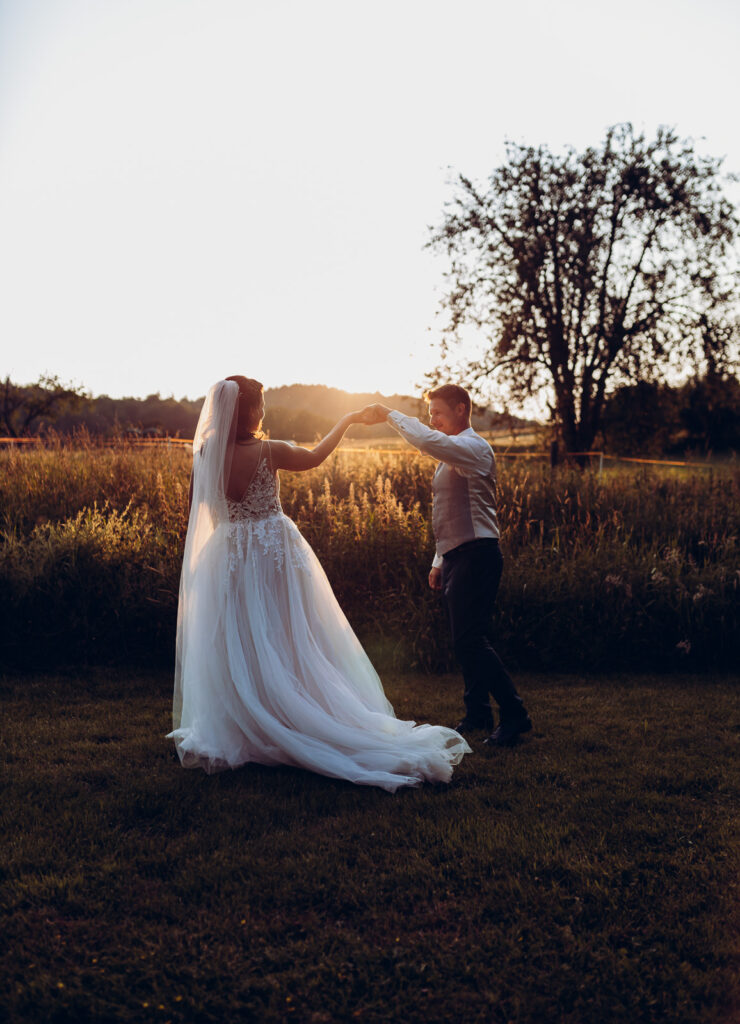 Tanzendes Brautpaar im Sonnenuntergang beim Brautpaarfotoshooting mit Hochzeitsfotografin Anika Hellemann in Osterode, Northeim und Göttingen